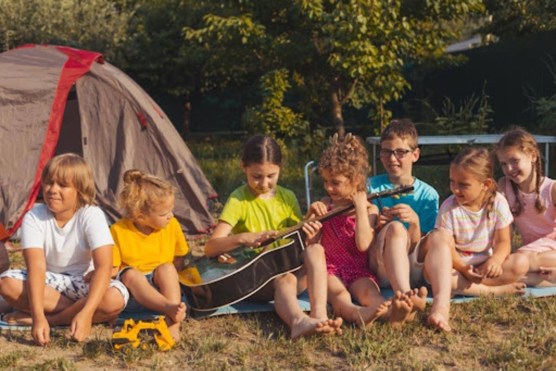Children at camp playing a guitar